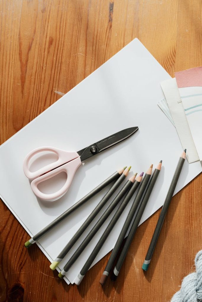 Mastering the First Impression: Your intriguing post title goes here A collection of colored pencils, scissors, and paper on a wooden table, ideal for artistic projects.
